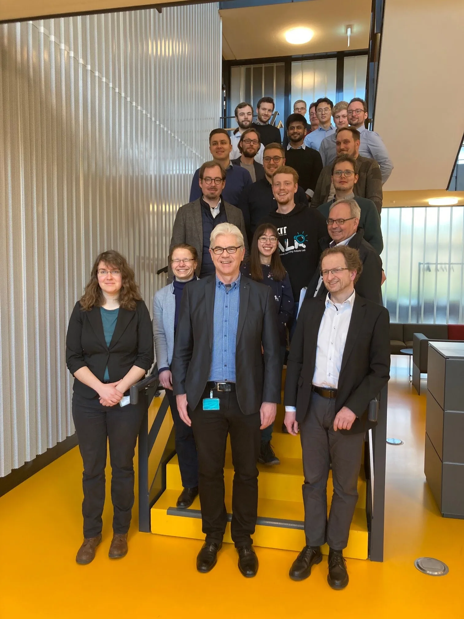 Group photo of the members of the Research Unit standing on a staircase.